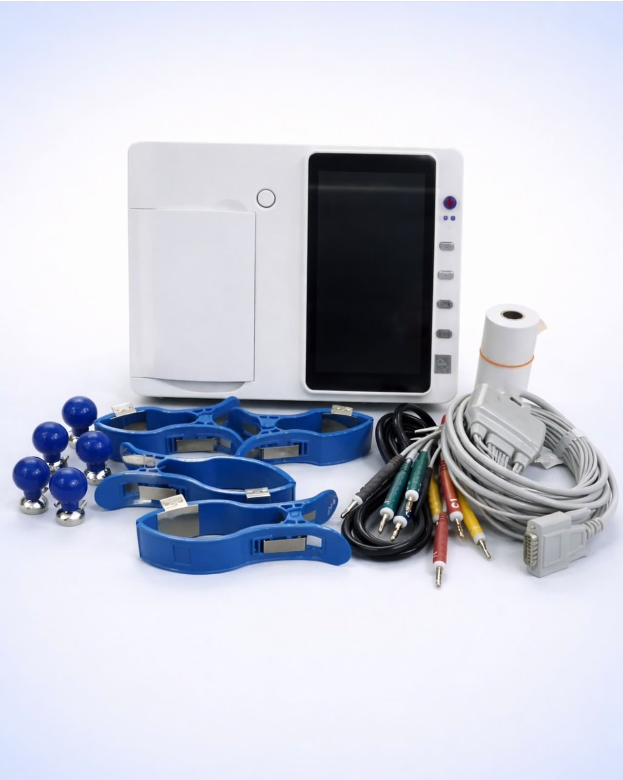 A twelve-lead ECG machine supplied with its patient cable, limb clamps, chest electrodes and recording paper.